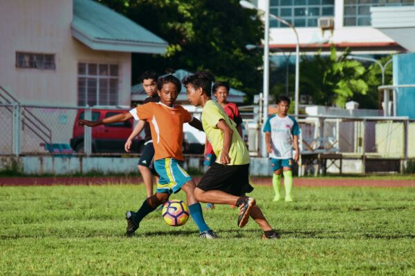 men's playing soccer during daytime