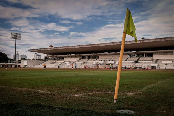 a yellow flag is in the middle of a soccer field